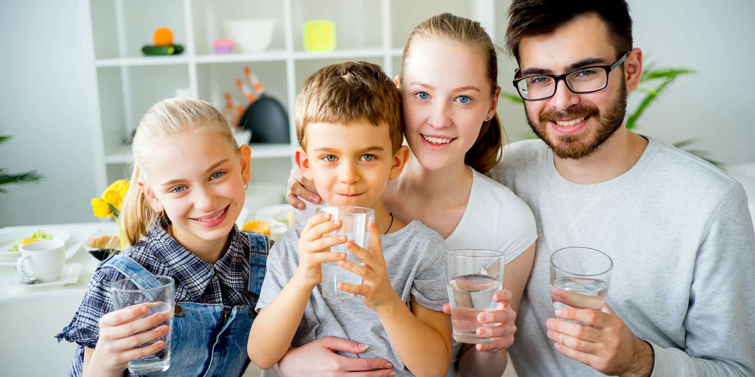 Happy family drinking a glass of water