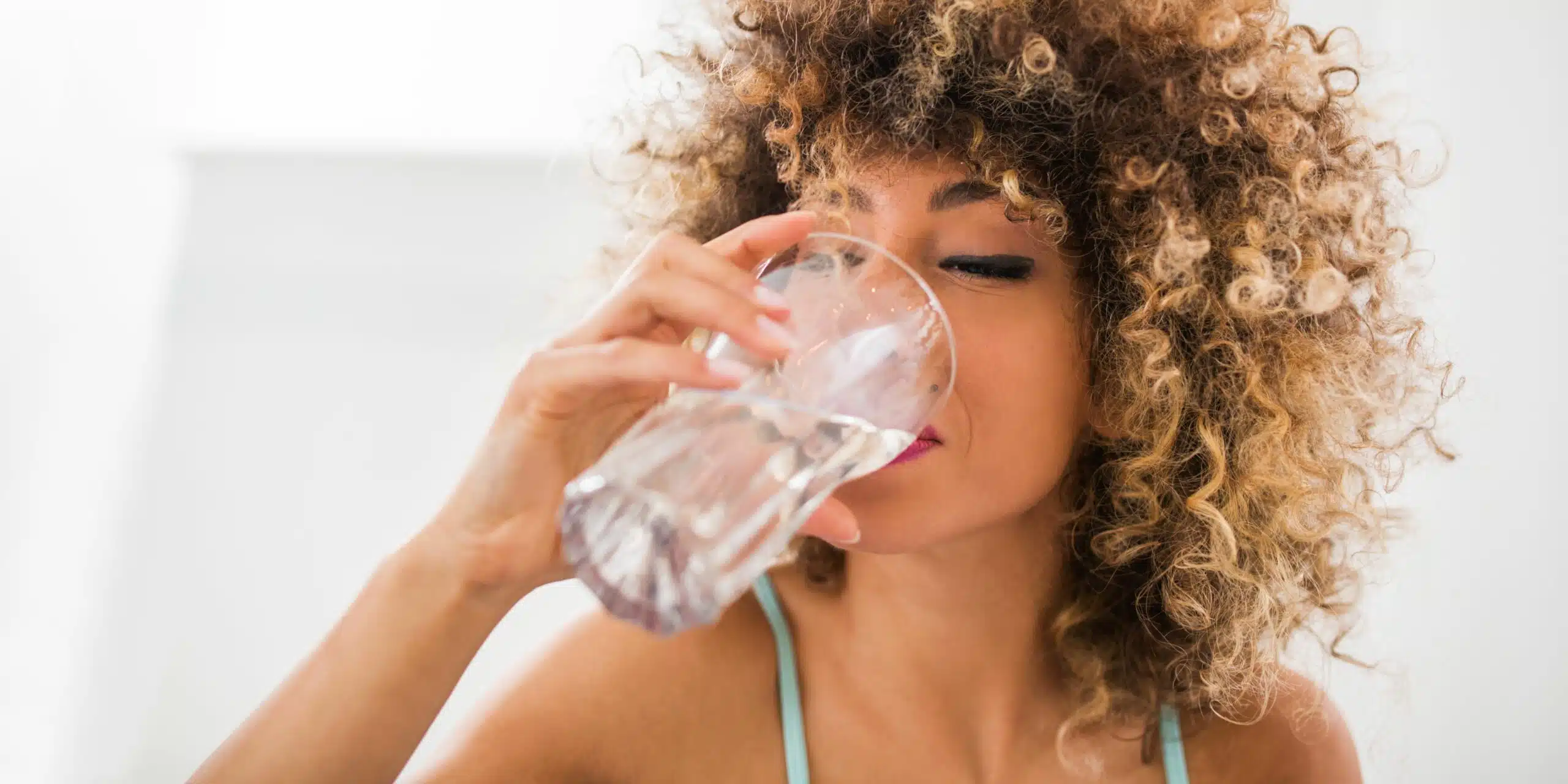 Lady drinking a glass of water.