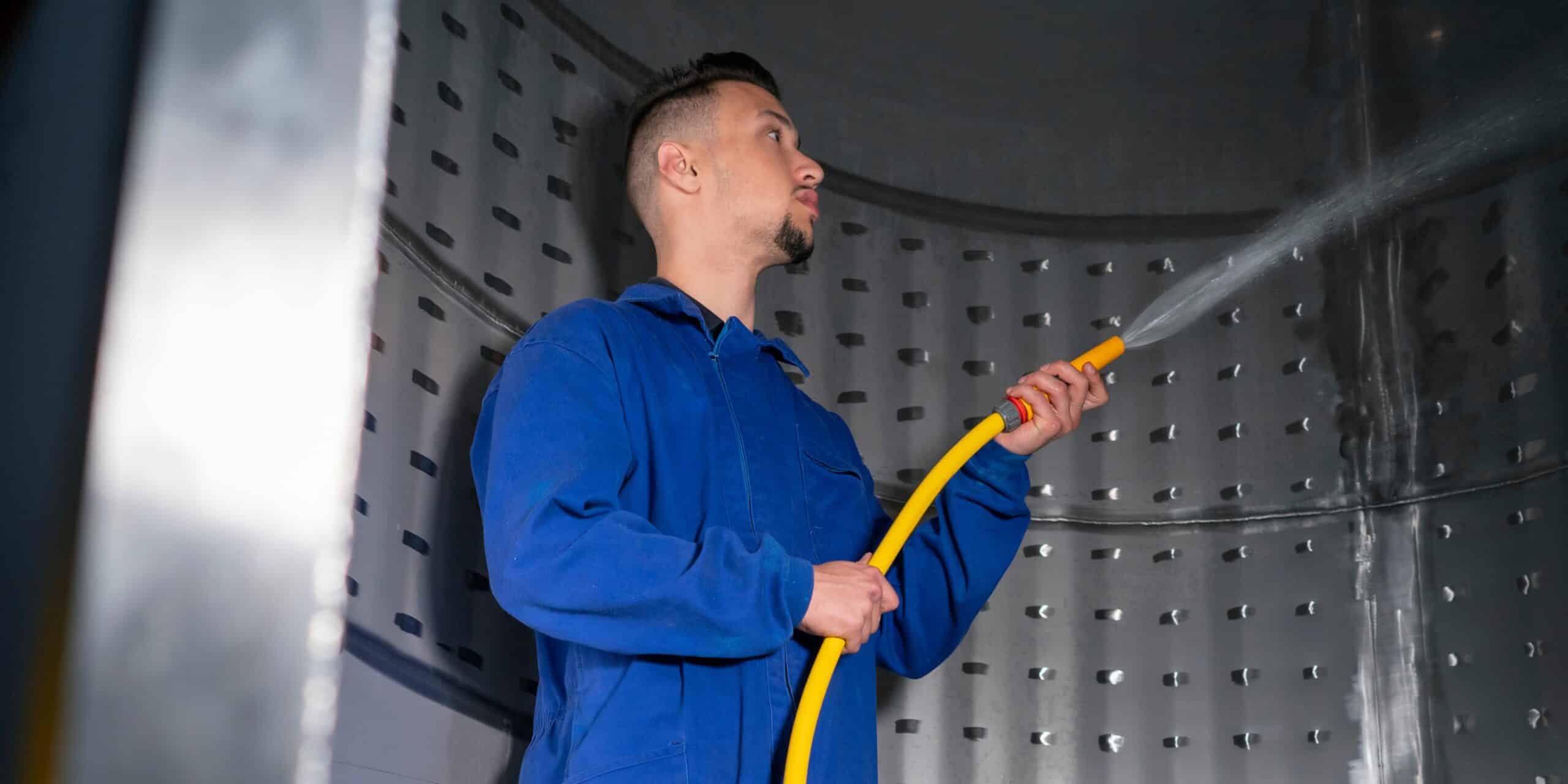 A man disinfecting the inside of a water tank